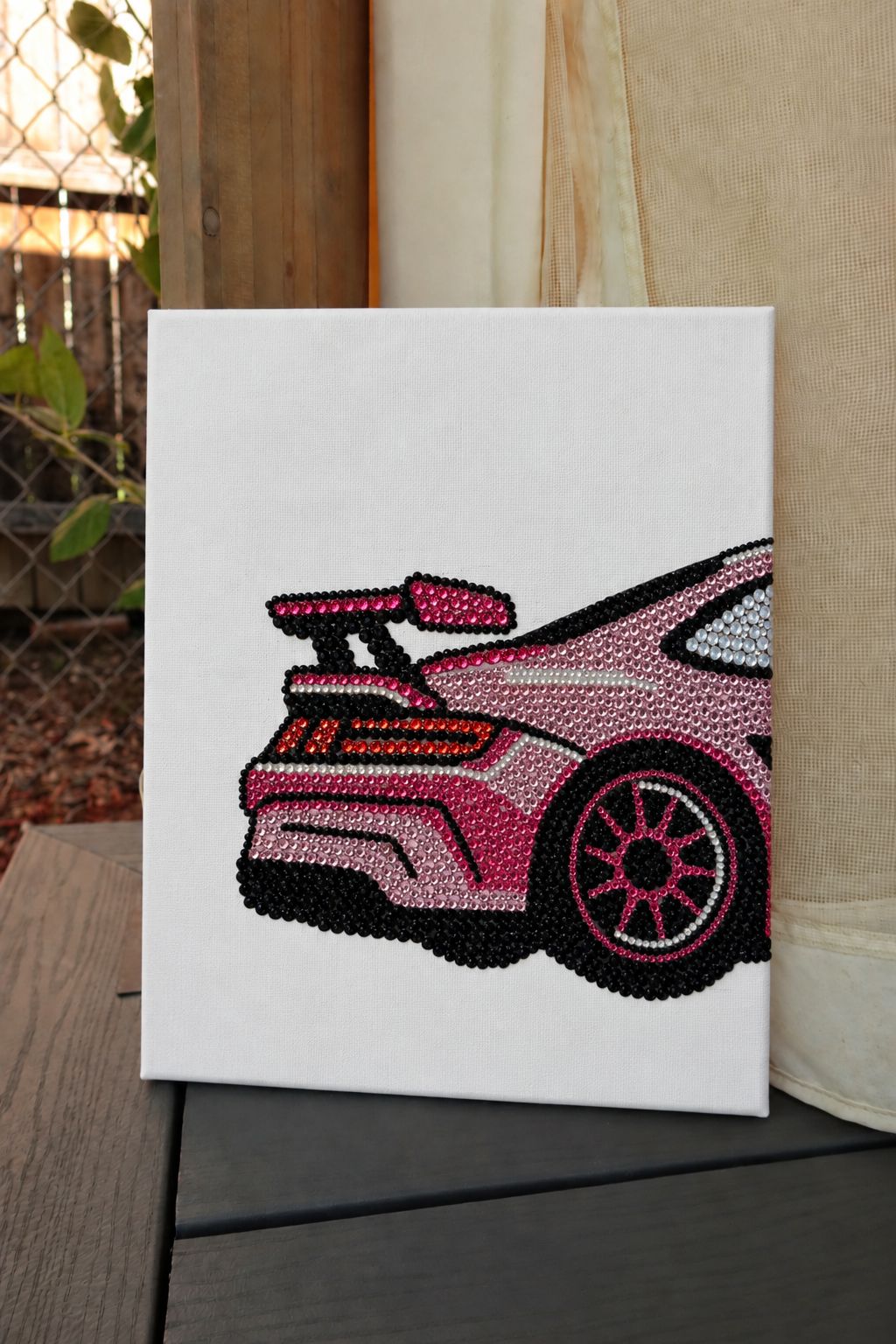 Finished pink Porsche rhinestone canvas propped outdoors